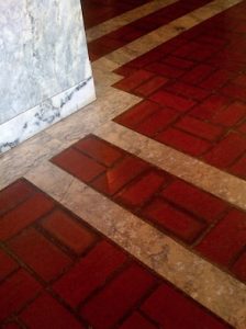 FAQ photo of white/grey marble pillar and red brick floor with inlaid gold marble grid paths